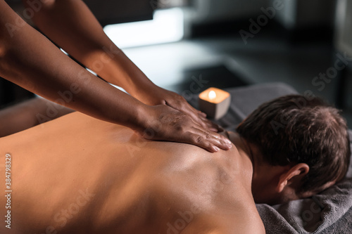 Masseur doing neck massage of man in oriental spa