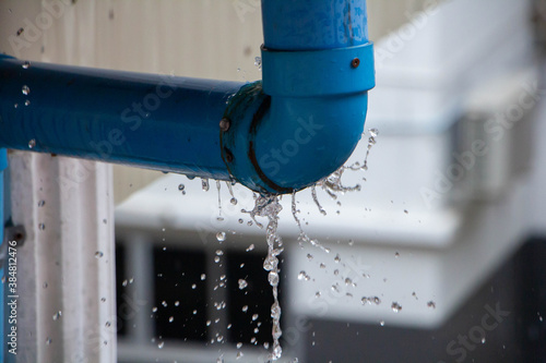 Closeup view of leaked and splash water from the plastic pipe during the rainy day