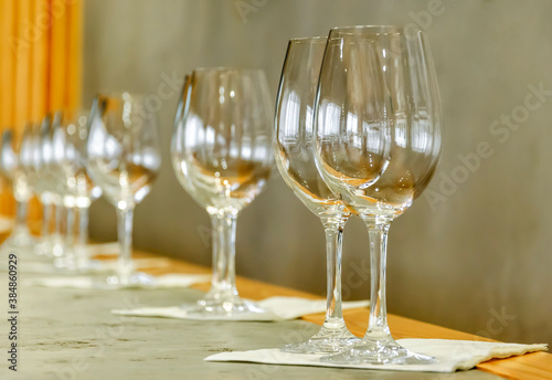 Empty wine glasses stand in a row on the table. Ready for wine tasting.