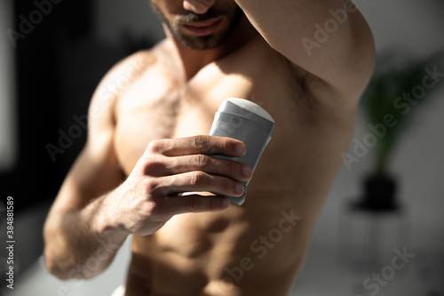 Cropped shot of young handsome man applying deodorant