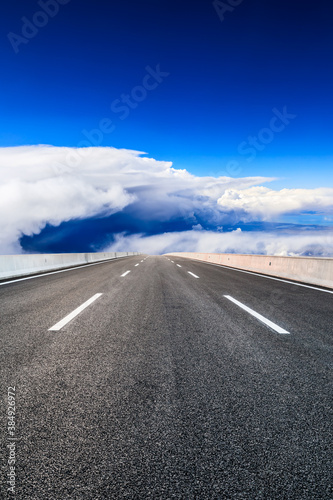 Empty asphalt road and blue sky with white clouds scenery.