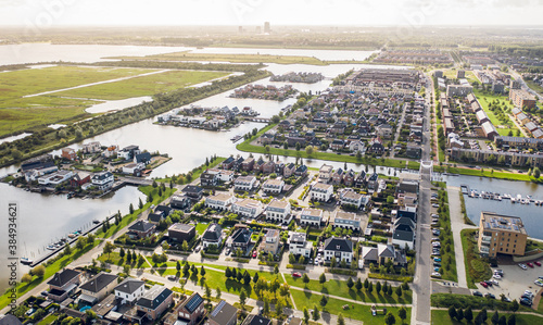 Modern suburban area Noorderplassen in Almere, The Netherlands, featuring artificial islands, located on Flevoland polder, surrounded by nature and the Nieuwe Land national park. Aerial view.