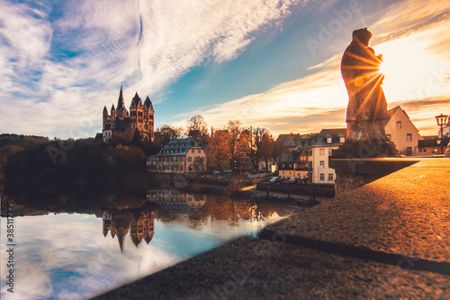 The cathedral in Limburg Germany. nice view over an old bridge with statue and the river at sunrise
