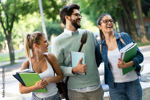 Group of happy university students studying together and having fun outdoors