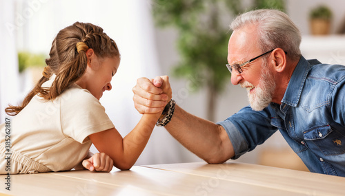 Grandfather arm wrestling with granddaughter.