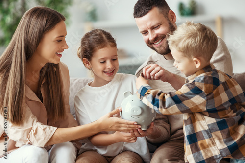 financial planning family mother father and children with piggy Bank at home