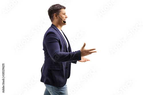 Profile shot of a young male keynote speaker with a hands free mic gesturing with hands