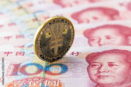 one hundred yuan banknotes, next to an e-RMB gold coin, digital version of the yuan. Concept of new digital currency of the popular republic of china