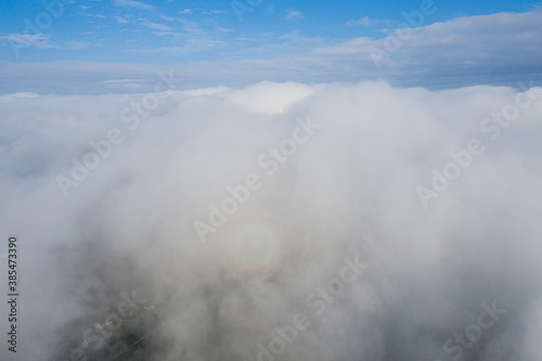 Aerial view over the sky clouds in day time with solar halo on the clouds