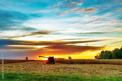 Corn Picker in the first light of day as it sits in a corn field.