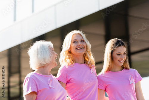 Selective focus of women with signs of breast cancer awareness laughing outdoors