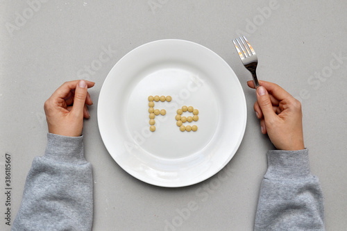 Sign of the trace element "iron" from tablets on a white plate. Iron deficiency in the body 