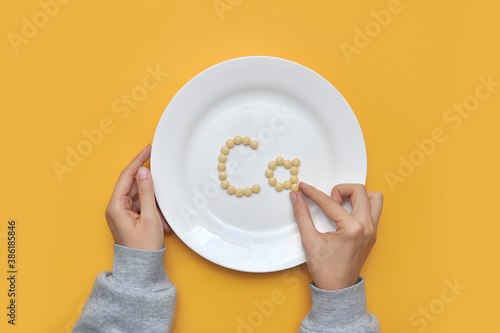 Sign of the trace element "calcium" from tablets on a white plate. calcium deficiency in the body