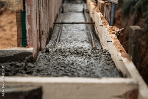 Timber formwork with metal reinforcement for pouring concrete and creating a solid foundation for a building or fence. Construction process