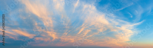 Majestic vanilla sky at evening. Azure sunset heaven with golden pink cirrus clouds over the horizon. Panoramic shot of pastel colored skyscape. Beauty in nature.