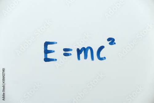 E=mc² written on a white board. The famous equation of Energy equals mass times the speed of light squared by Albert Einstein.