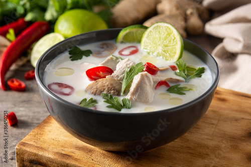 Traditional Thai food Tom Kha Gai in bowl on wooden table and ingredients. 