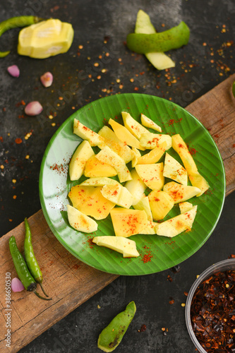Sliced green mango with chili powder , salt street food snack Kerala. Organic Fresh mango table salt mixed with ground chilli . Indian Traditional Raw Mango Pickle. Bengali seasonal fruit unripe mango