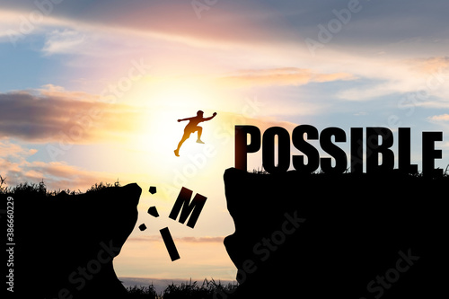 Mindset concept ,Silhouette man jumping over impossible and possible wording on cliff with cloud sky and sunlight.