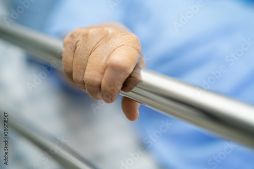 Asian senior or elderly old woman patient lie down handle the rail bed with hope on a bed in the hospital.