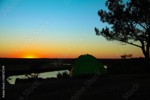 View of tent near river in evening