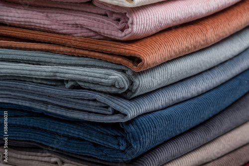 Multicolored fabrics folded in a stack . Multi-colored corduroy textile. Velvet.