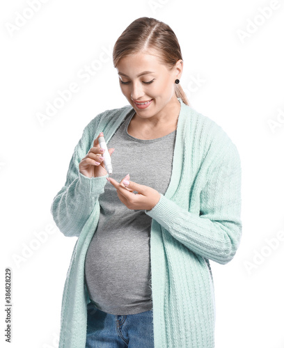 Pregnant diabetic woman with lancet pen on white background