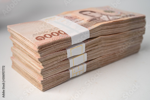 Stack of Thai baht banknotes on wooden background, business saving finance investment concept.