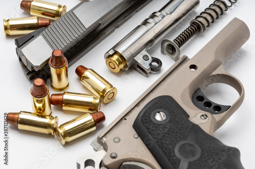 Parts of 1911 gun model and .45 bullets on white background