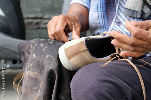 Process of manual shoe reparation, sole and welt fixing and stitching