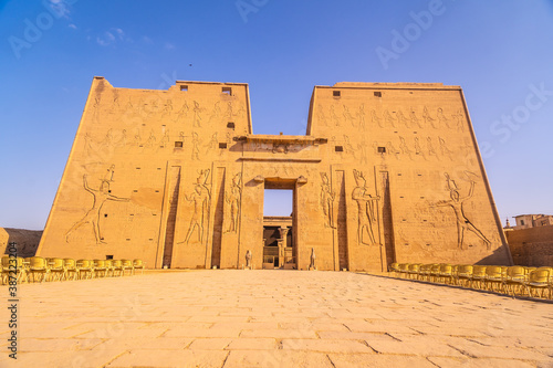 Facade with drawing of pharaohs of the Temple of Edfu in the city of Edfu, Egypt. On the bank of the Nile river, geco-Roman construction, temple dedicated to Huros