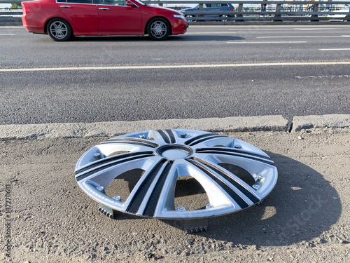 Lost hubcap on the side of a city road