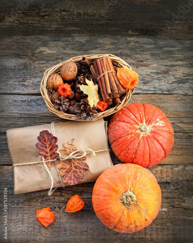 autumn composition with pumpkins, gift box, cinnamon and nuts on wooden table. Fall harvest season concept. thanksgiving and halloween holiday. 