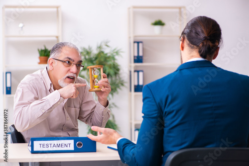 Young male lawyer and old man in testament and time management c