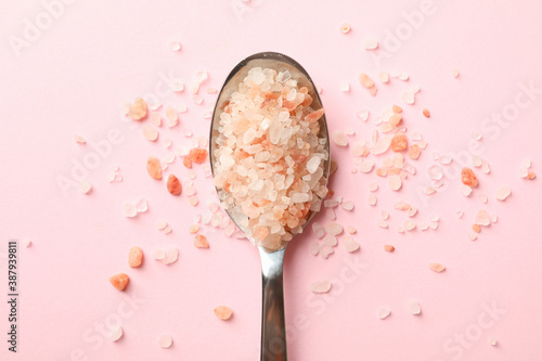 Spoon with pink himalayan salt on pink background