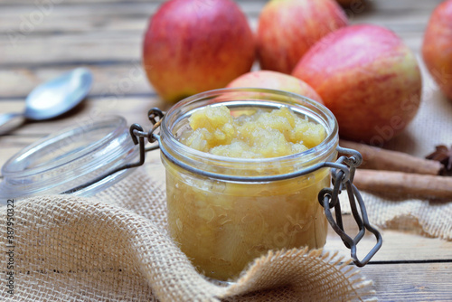 close on homemade compote in a glass jar with red apples background