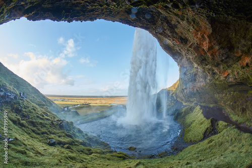Beautiful waterfall in Iceland, Icelandic waterfall Seljalandsfoss, Photo shot from cave inside of waterfall