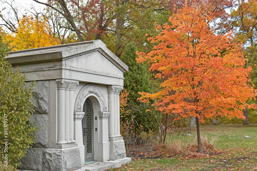 The height of autumn surrounds a private mausoleum in a cemetery