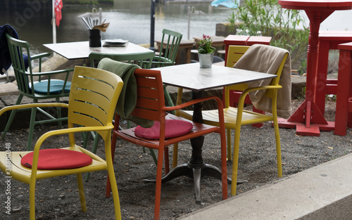 Empty tables and chairs on the terrace of a restaurant on the riverside