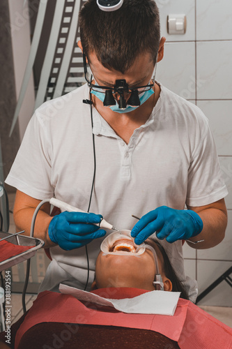 The dentist removes tartar using ultrasound, the patient at the dentist.