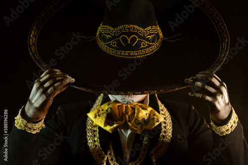 mexican charro holding his black hat