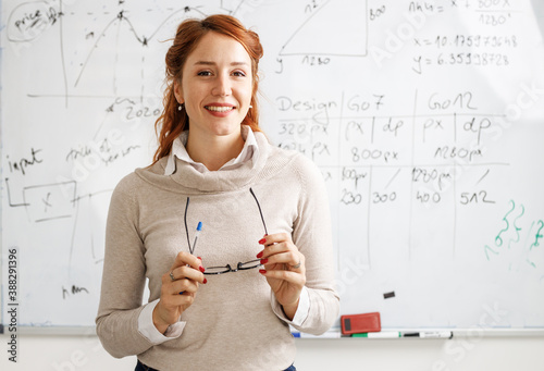 Portrait of red hair female professor. She lecture about new technologies and software development.