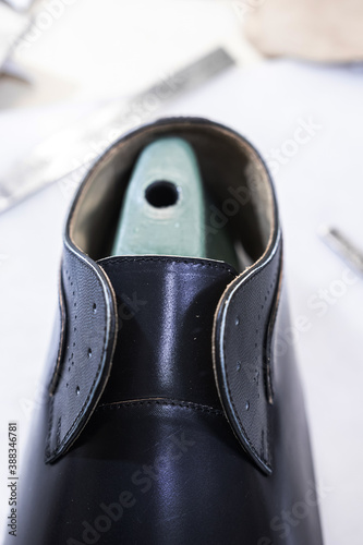 black leather blank and green boot tree on the table, one of the stages of shoe assembly