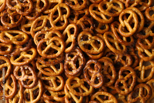 Tasty salty cracker pretzels on whole background