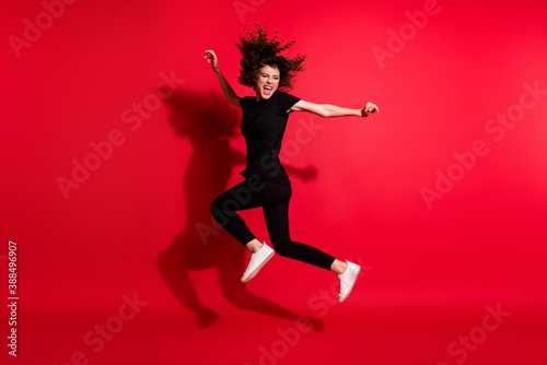 Photo portrait full body view of crazy girl jumping up isolated on vivid red colored background