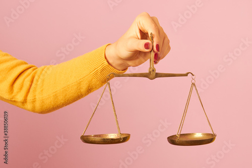 woman hand holding a balance on pink background