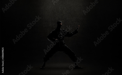 japanese ninja in black uniform on black background
