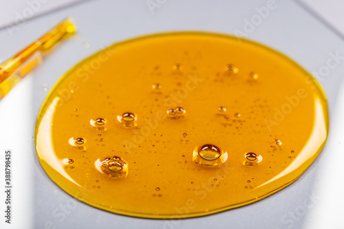 Yellow viscous liquid lecithin with bubbles on glass