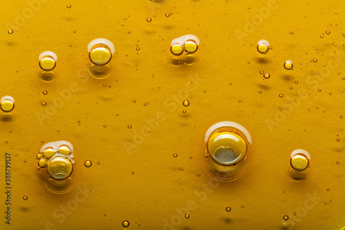 Yellow viscous liquid lecithin with bubbles on glass