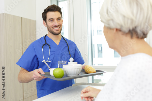 nurse serving a breakfast to patient in hospital